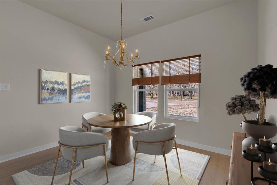 Dining room with a notable chandelier and light hardwood / wood-style flooring