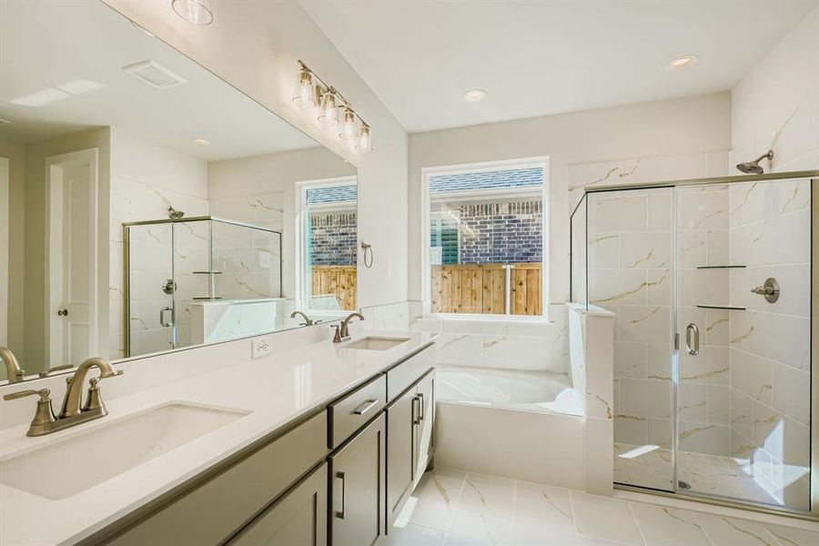 Bathroom with a bath, a marble finish shower, double vanity, and recessed lighting