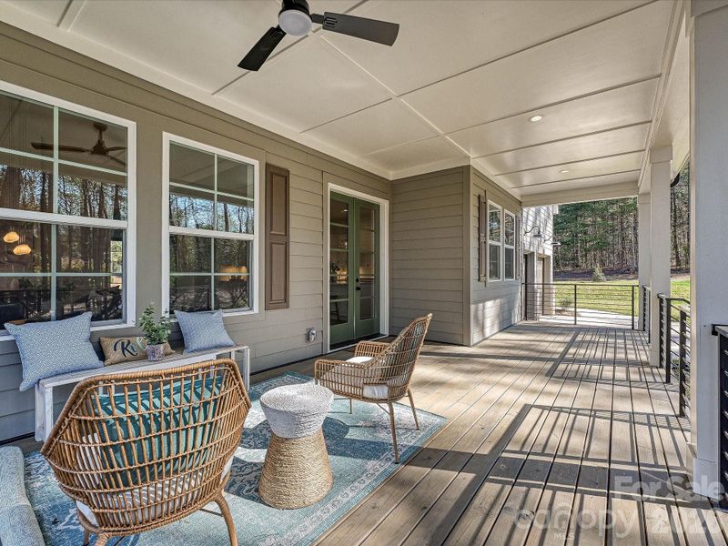 Spacious covered deck overlooking a private wooded backdrop, perfect for relaxing, entertaining, and enjoying peaceful outdoor living year-round.