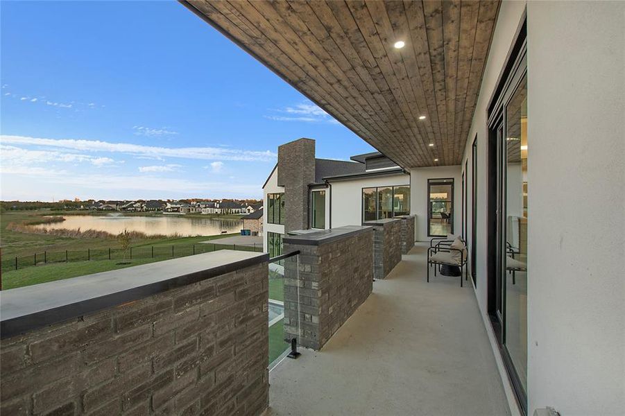 View of patio with a balcony and a water view