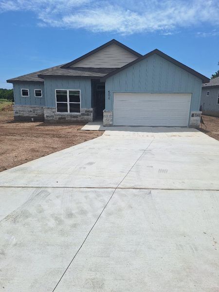 Single story home featuring driveway, an attached garage, and board and batten siding Single story home featuring driveway, an attached garage, and board and batten siding