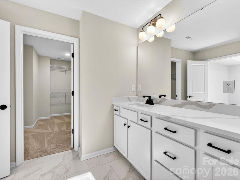 Enjoy spending time in the primary bathroom with designer features large, tiled shower with bench, large Dual vanity with quartz countertops, Tiled flooring, separate toilet and large walk-in closet