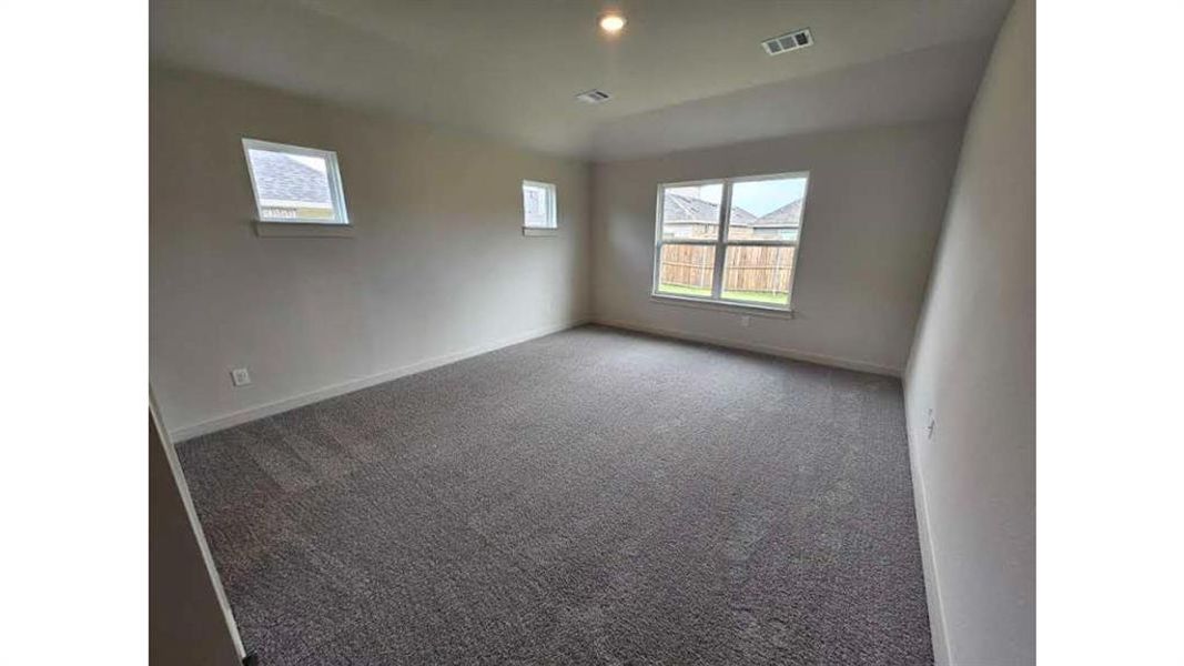Spacious room featuring neutral carpeting, multiple windows, recessed lighting, and light-toned walls Spacious room featuring neutral carpeting, multiple windows, recessed lighting, and light-toned walls