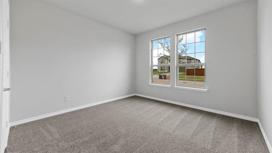 Neutral tone wall finishes with two grid-pattern windows, light gray carpet flooring, and white baseboards