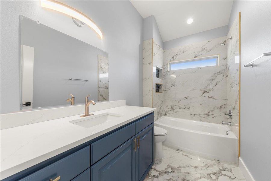 Full bathroom featuring vanity, a combined bath / shower with marble appearance, and light marble finish flooring Full bathroom featuring vanity, a combined bath / shower with marble appearance, and light marble finish flooring