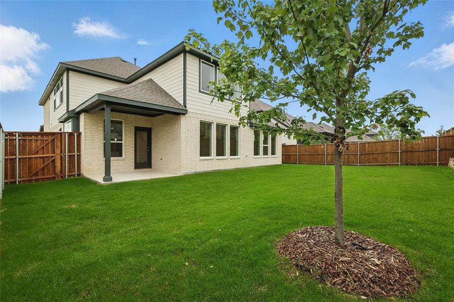 Rear view of property with roof with shingles, a patio, and brick siding Rear view of property with roof with shingles, a patio, and brick siding