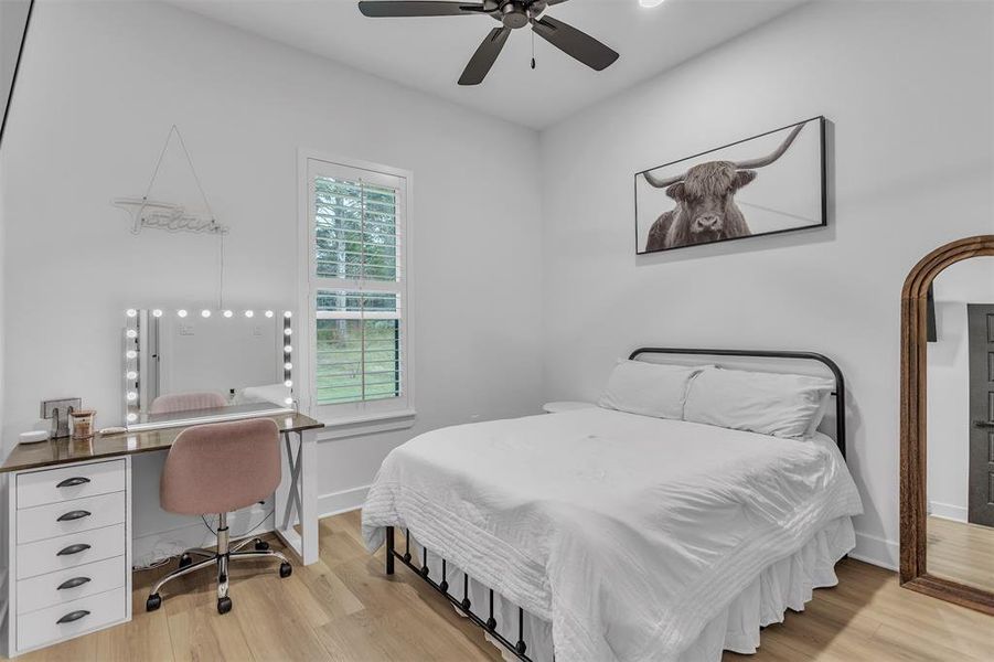 Secondary Bedroom #1 with light wood-style flooring and plantation shutters. Secondary Bedroom #1 with light wood-style flooring and plantation shutters.