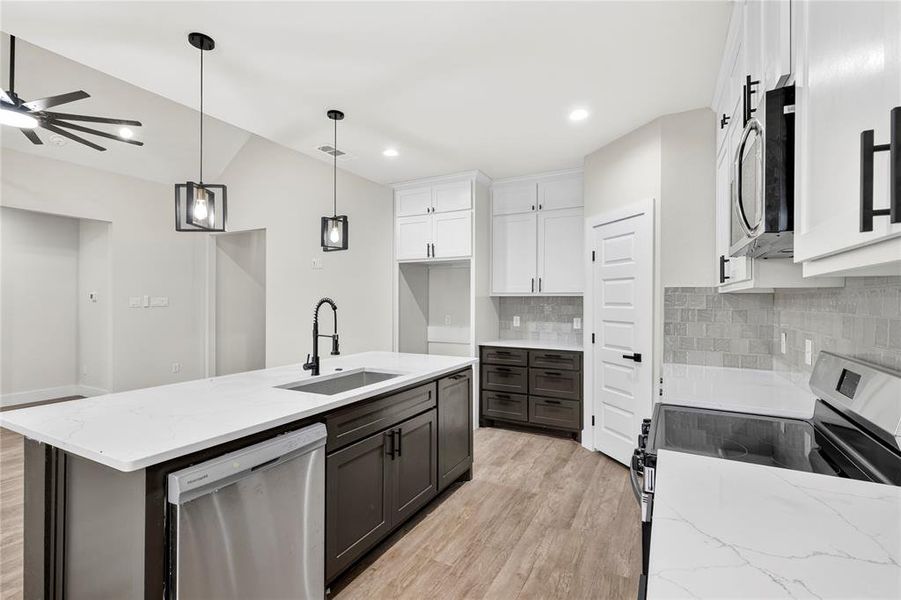 Spacious room featuring wood-finish flooring, light-colored walls, and crisp white trim