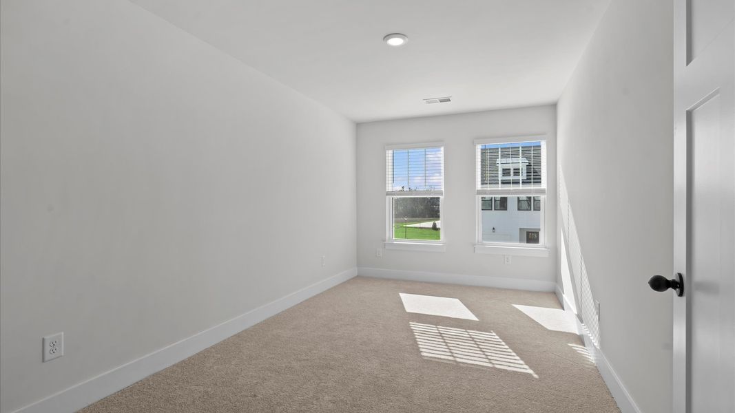 Elegant bedroom retreat featuring soft carpet and oversized windows that create a bright, welcoming space in Simpsonville, SC