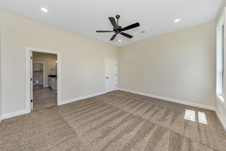 Unfurnished bedroom featuring ceiling fan and carpet floors