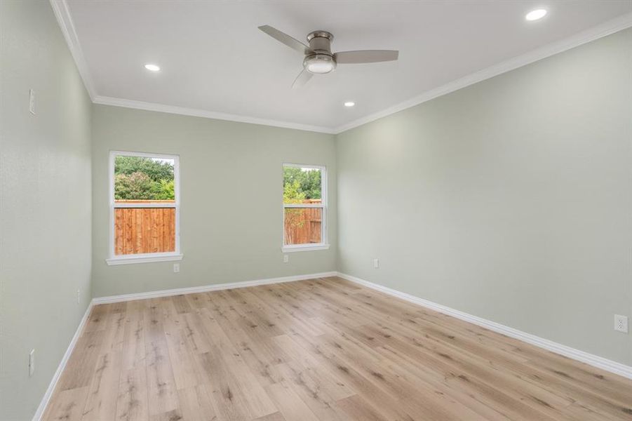 Unfurnished room featuring light hardwood / wood-style flooring, ceiling fan, and crown molding