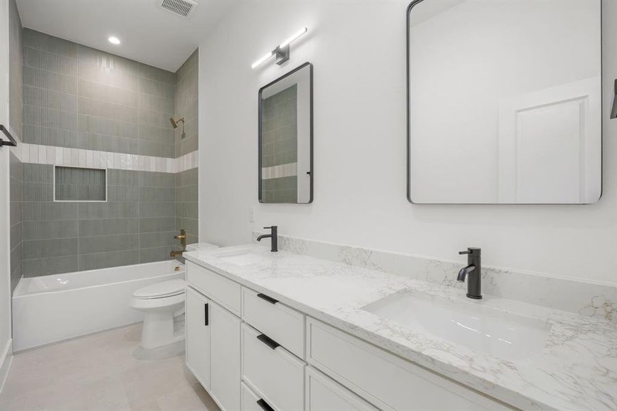 The upstairs guest hall bathroom features dual sinks and a tub-shower combination accented by a designer tile surround, creating a stylish and functional space for family and guests. The upstairs guest hall bathroom features dual sinks and a tub-shower combination accented by a designer tile surround, creating a stylish and functional space for family and guests.