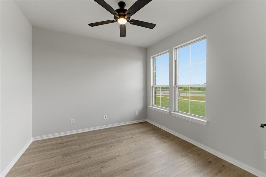 Spare room with light wood finished floors and a ceiling fan
