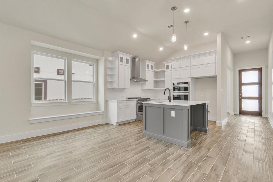 An open concept kitchen features sleek appliances and a spacious island with a breakfast bar.