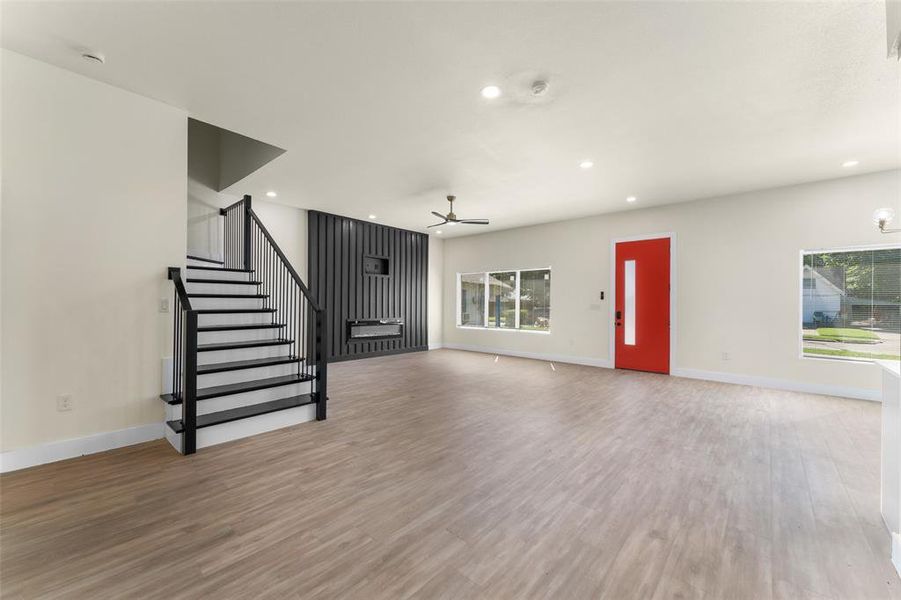 Unfurnished living room featuring a ceiling fan, stairs, wood finished floors, and recessed lighting