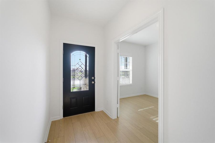 Entryway with light wood-style floors and baseboards