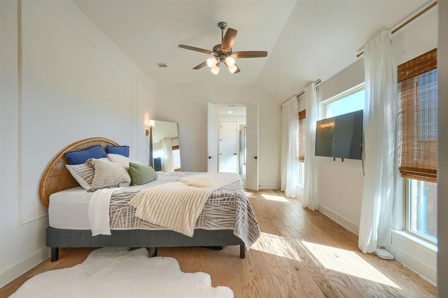 Bedroom with ceiling fan, lofted ceiling, and light hardwood / wood-style flooring