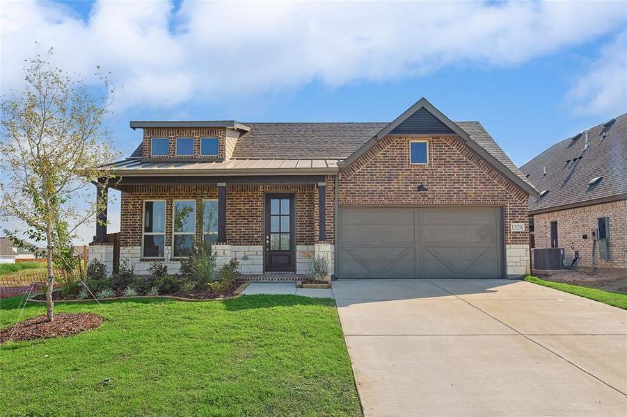 View of front of property with covered porch, central AC unit, a front yard, and a garage