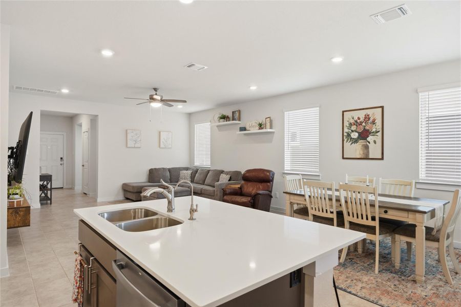 Kitchen with a center island with sink, open floor plan, ceiling fan, stainless steel dishwasher, and recessed lighting
