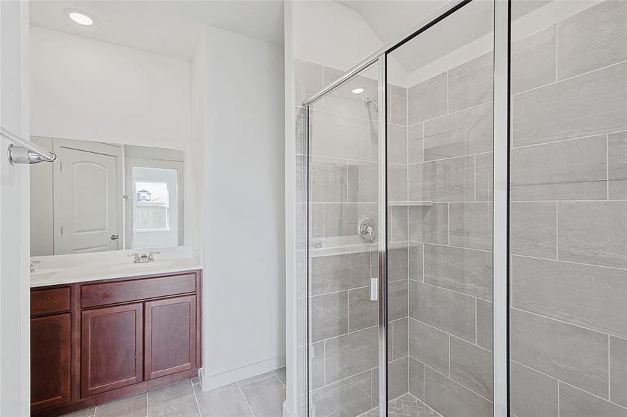 Bathroom with tile patterned flooring, vanity, and a shower with shower door