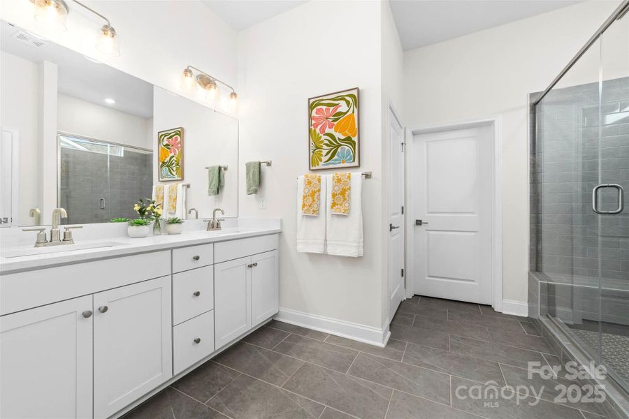 Primary bathroom with dual vanities and separate water closet