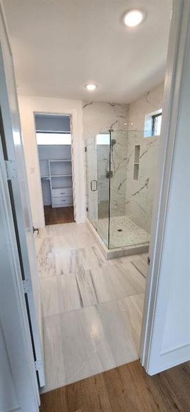 Bathroom with wood-type flooring and a shower with door