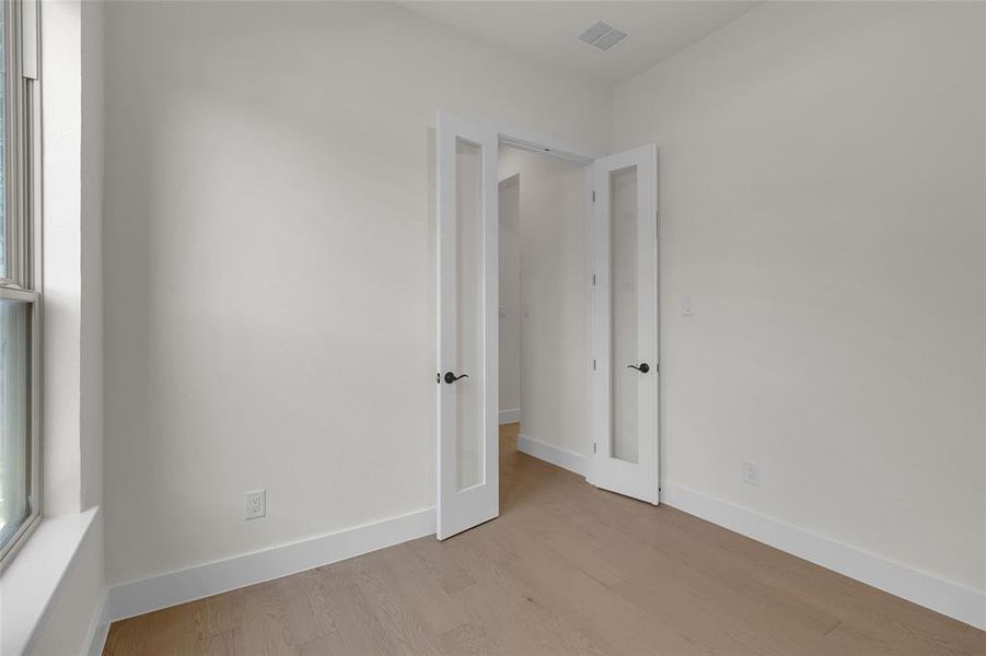 Room featuring wood-finish flooring, white baseboards, and neutral wall paint