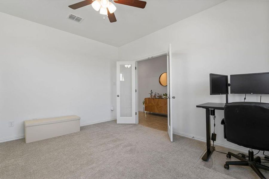 Office area with light colored carpet and ceiling fan Office area with light colored carpet and ceiling fan