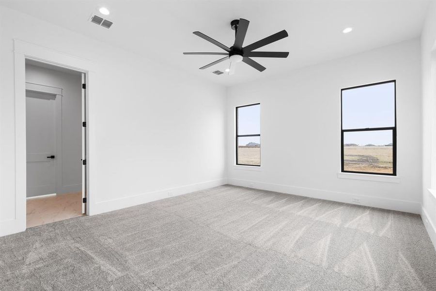 Spare room featuring ceiling fan and light colored carpet