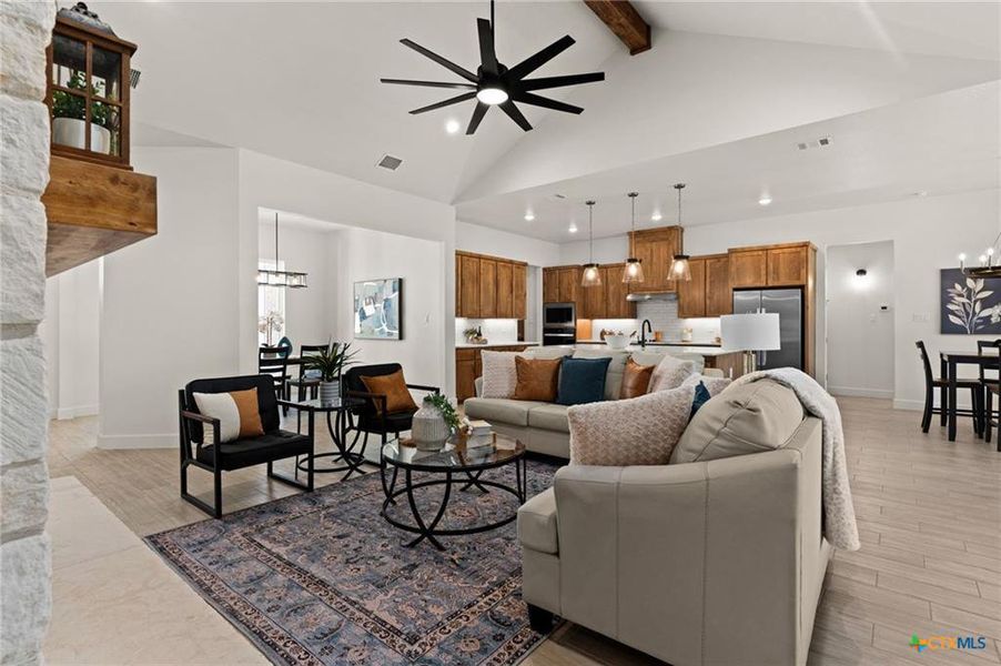Living room featuring a chandelier, ceiling fan, beam ceiling, high vaulted ceiling, and recessed lighting
