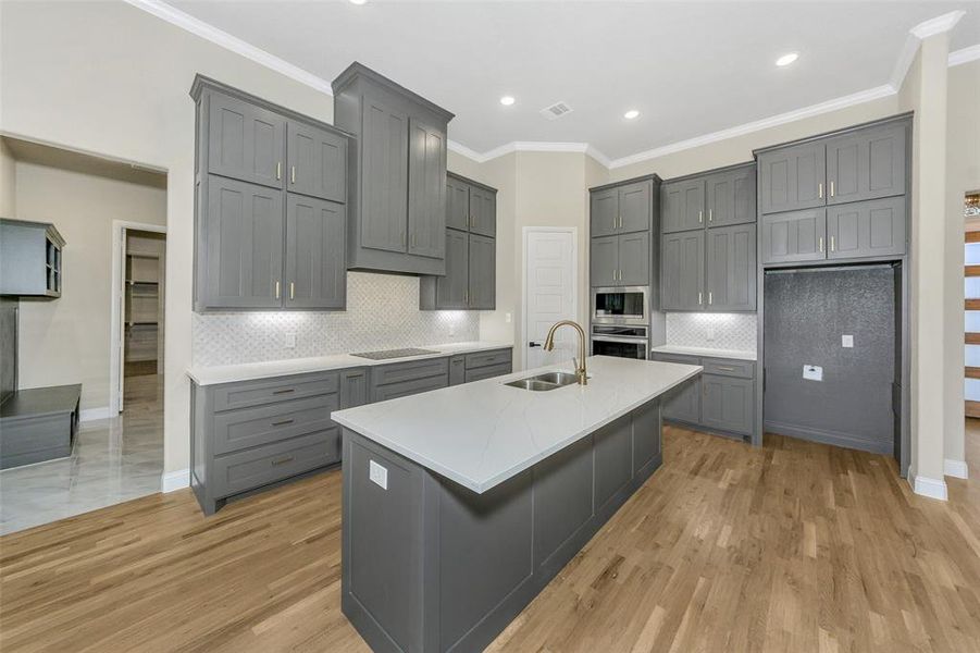 Kitchen featuring gray cabinetry, sink, appliances with stainless steel finishes, and light hardwood / wood-style flooring