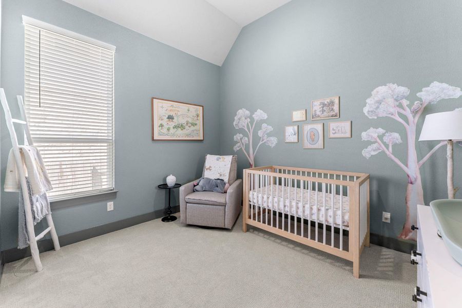 Light-colored carpeting complements soft blue walls and a vaulted ceiling