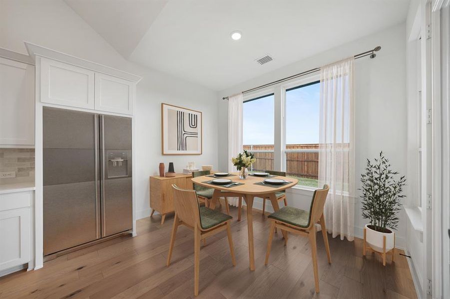 Dining space with light wood-type flooring, recessed lighting, and vaulted ceiling