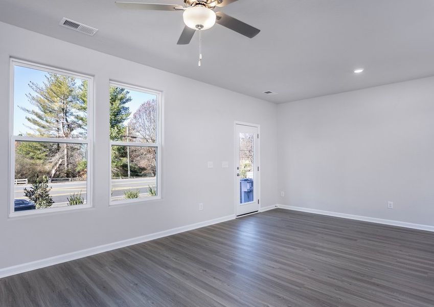 The living room has lots of space and windows that let in lots of natural light