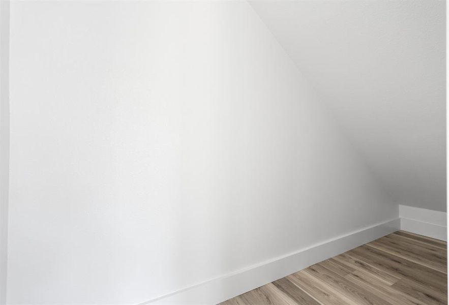 Additional living space with wood finished floors and baseboards