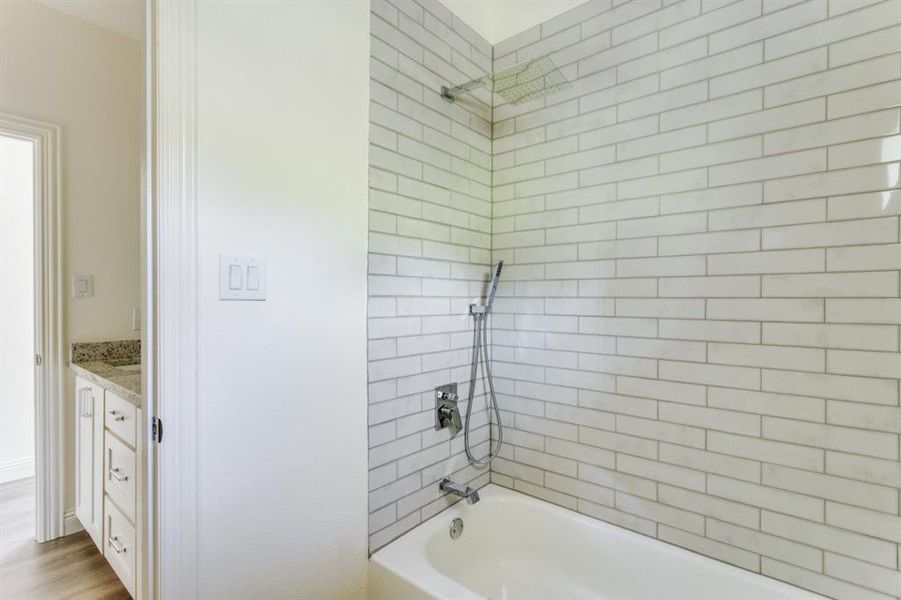 Bathroom featuring tub / shower combination and vanity