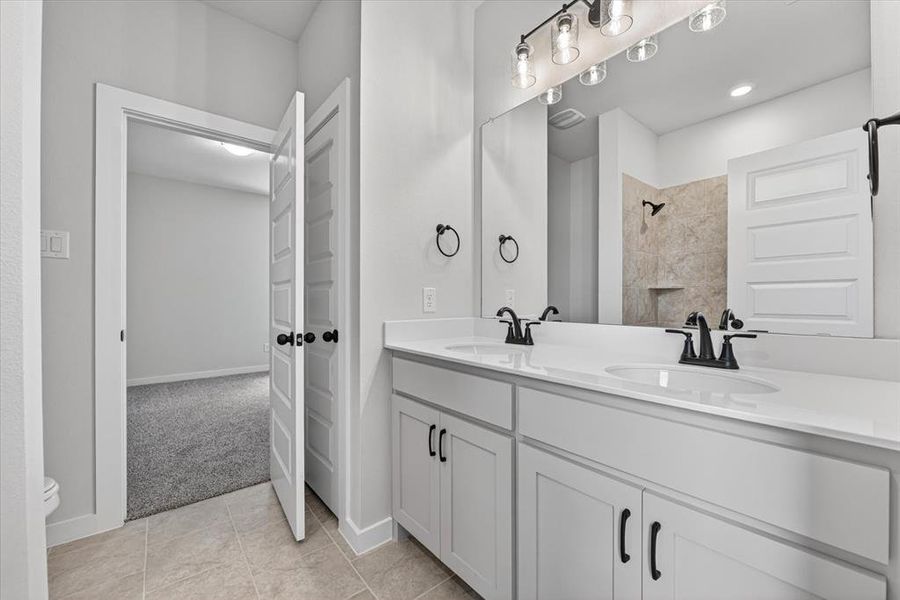 Dual vanity with white cabinetry, matte black fixtures, and a spacious mirror