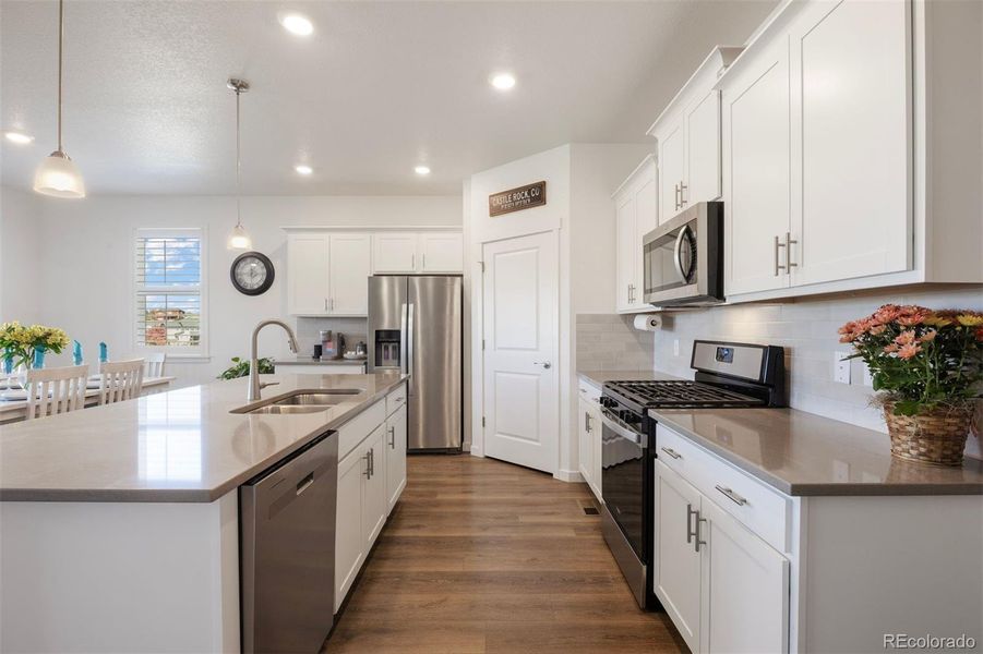 White cabinetry and quartz counters create a timeless backdrop for daily living.