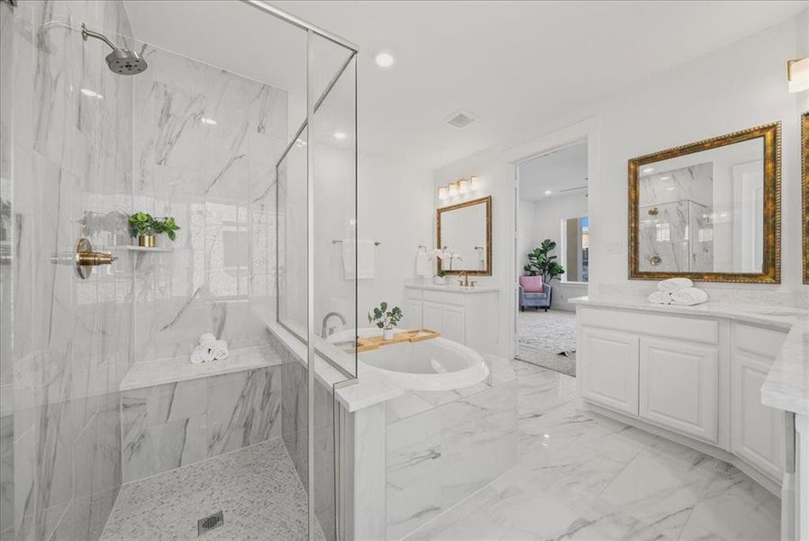 Bathroom featuring two vanities, separate shower, garden tub, light marble finish floors, and recessed lighting Bathroom featuring two vanities, separate shower, garden tub, light marble finish floors, and recessed lighting