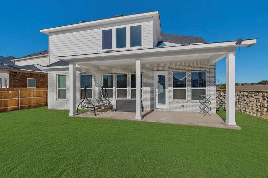 Rear view of house with brick siding and a patio