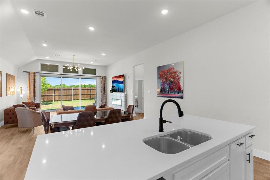 Kitchen with a sink, light countertops, open floor plan, light wood-style floors, and recessed lighting Kitchen with a sink, light countertops, open floor plan, light wood-style floors, and recessed lighting