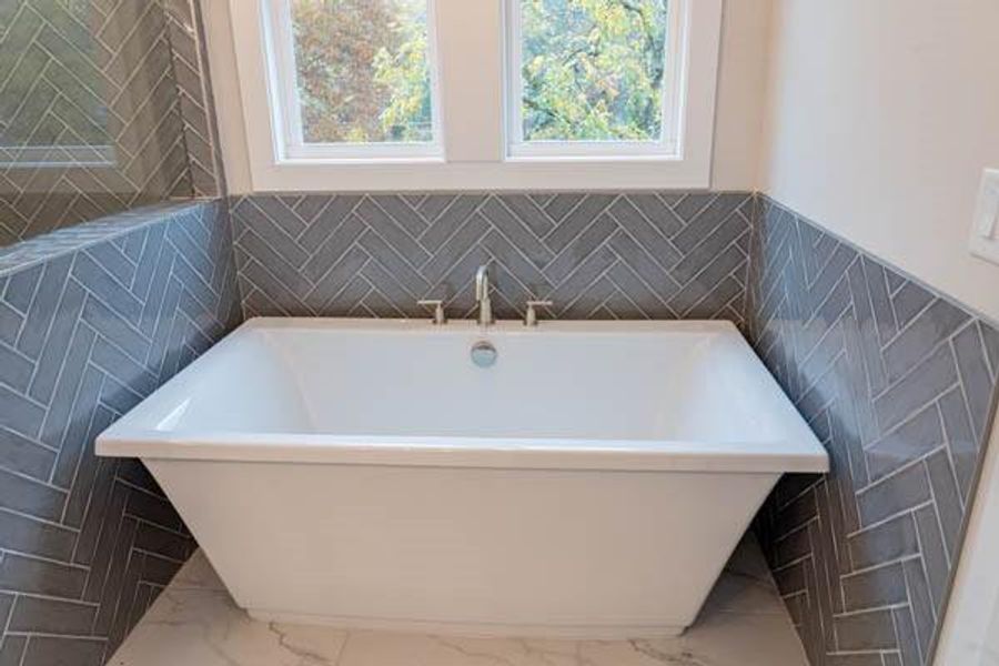 Bathroom with tile flooring, tile walls, and a bath to relax in Bathroom with tile flooring, tile walls, and a bath to relax in