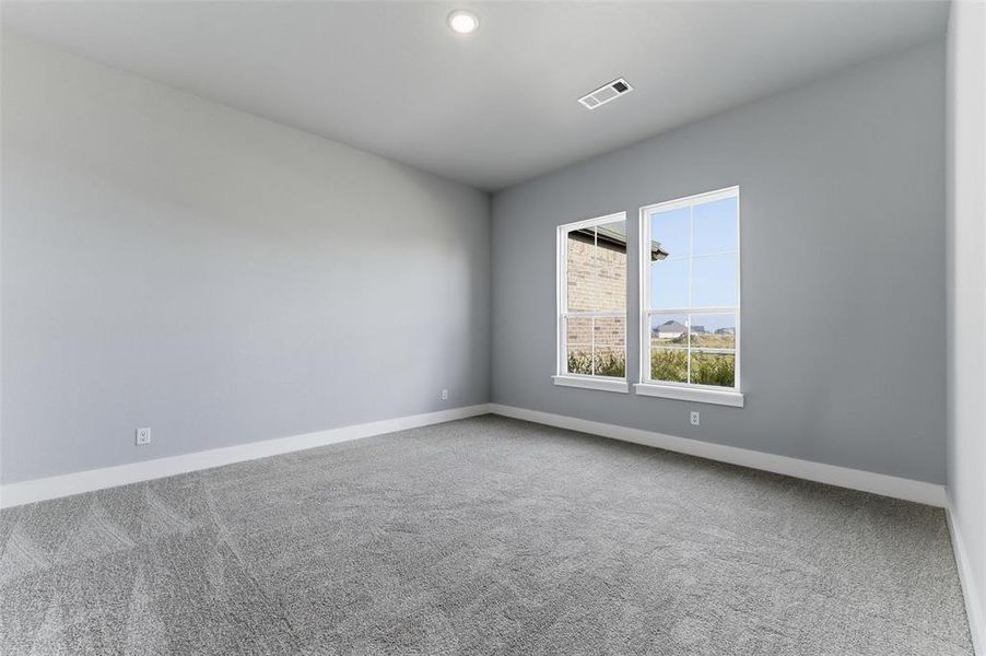Carpeted spare room featuring baseboards