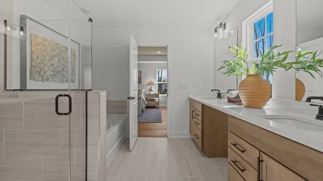 Wynwood home plan primary bathroom with separate vanities, linen closet, tile shower and large bath tub Wynwood home plan primary bathroom with separate vanities, linen closet, tile shower and large bath tub