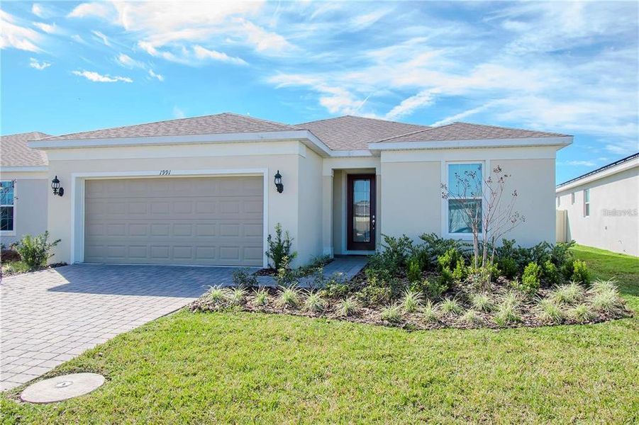 Front exterior of a new home in Tohoqua Reserve, Kissimmee, FL, highlighting curb appeal (Image 1).