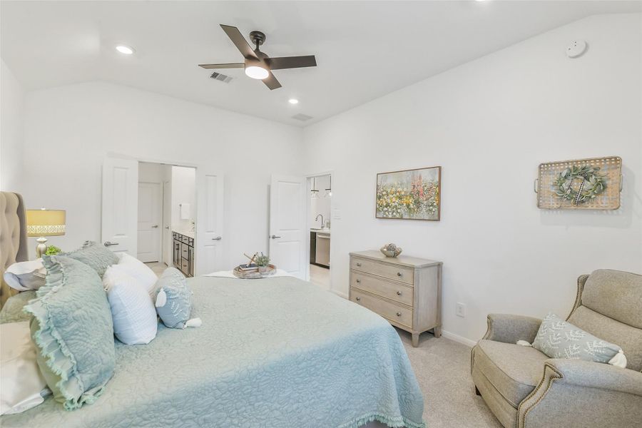 The serene primary bedroom transitions effortlessly through double doors to the ensuite bathroom.