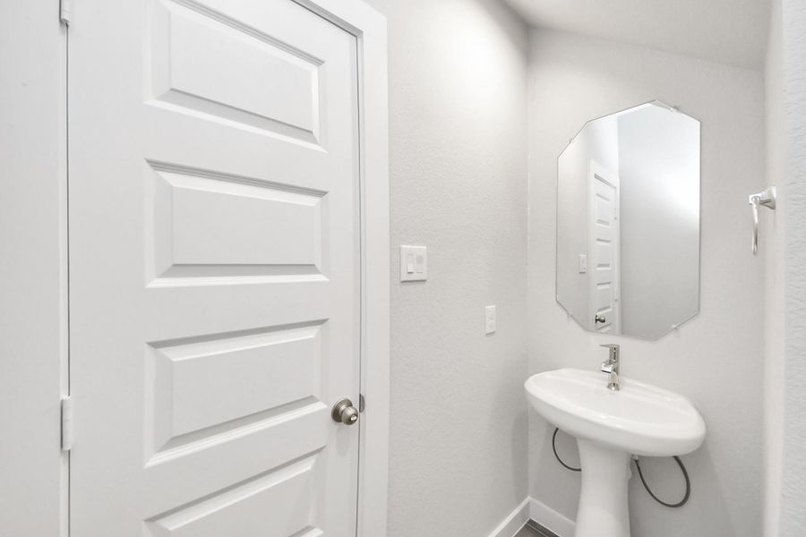 Step into this bright and airy half bath, where a sleek pedestal sink and modern hardware elevate the space with contemporary charm. Step into this bright and airy half bath, where a sleek pedestal sink and modern hardware elevate the space with contemporary charm.
