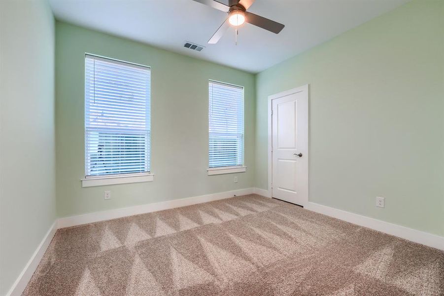 Carpeted spare room with ceiling fan