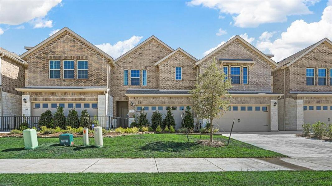 Traditional-style home with brick siding, concrete driveway, and an attached garage