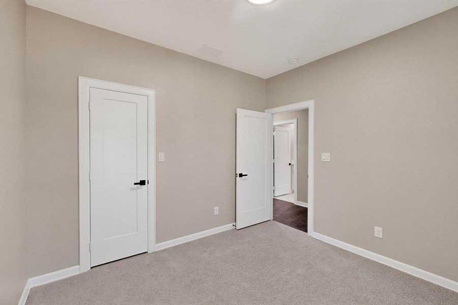 Unfurnished bedroom with baseboards and carpet Unfurnished bedroom with baseboards and carpet
